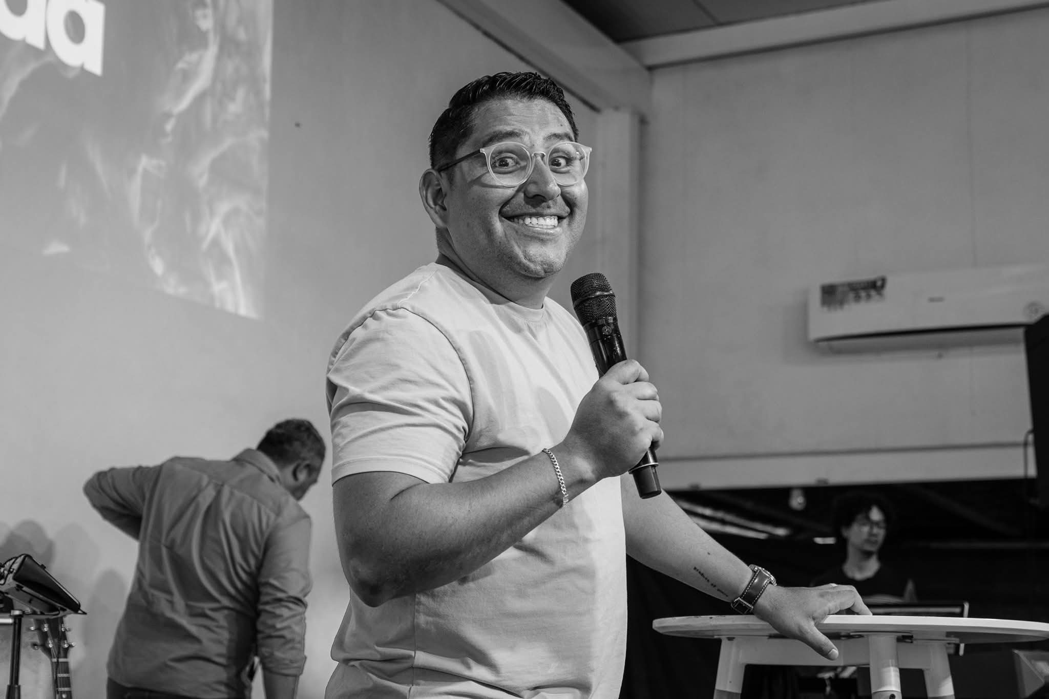 Joven con micrófono y la congregación al fondo